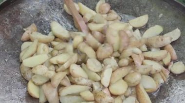 Kafeler ve restoranlar, yemek pişirme, piknik, doğu mutfağı konsepti - patatesleri, kamp ateşi üzerinde pişirmek için büyük bir tavada ahşap spatulayla karıştırmak: et, sebze diğer yemekler.