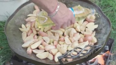 Kafeler ve restoranlar, yemek pişirme, piknik, doğu mutfağı konsepti - açık havada yemek pişirmek için büyük kızartma tavasına yakın patatesler: et, sebze, balık ve diğer yemekler.