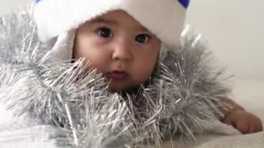 Mutlu Noeller ve mutlu yıllar, bebek, çocukluk, tatil konsepti - yakın plan 6 aylık, kırmızı ve mavi Noel Baba şapkalı çıplak bebek ve ablası süslemelerle dolup taşıyor Noel ağacı