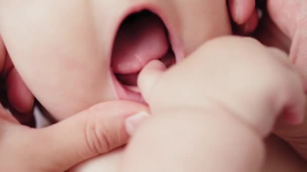 Orvostudomány, gyermekgyógyászat, fogászat, újszülött koncepció - anya nyitott baba száj mutatja első tej tejfogak kitört a duzzadt íny. szuper közelkép portré baba mosolygós szájával nyitott örömteli — Stock videók