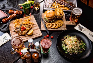 Sığır eti burger patates kızartması ve kızarmış tavuk. Kuzu kaburga suyu gözlük ile 