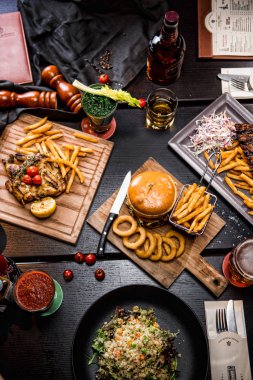 Sığır eti burger patates kızartması ve kızarmış tavuk. Kuzu kaburga suyu gözlük ile 