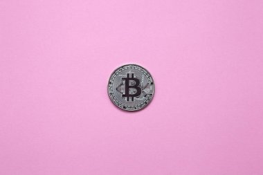 Bin yıllık pembe bir arka plan üzerinde gümüş bitcoin. Üstten Görünüm. Minimalizm. Yatay Yönlendirme