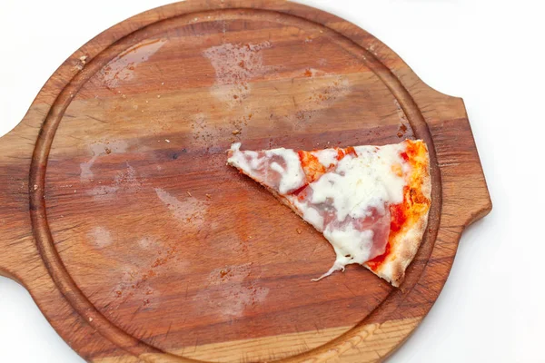 Última fatia de deliciosa pizza italiana com presunto e queijo em tábua de madeira na mesa branca. Hora da pizza. Vista superior. Close-up . — Fotografia de Stock