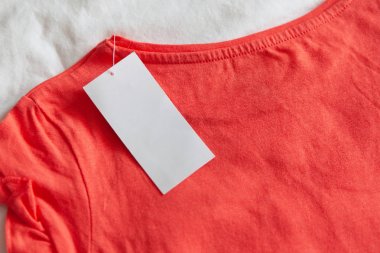 Yeni pembe kırmızı çocuk veya beyaz arka plan üzerinde temiz etiket ile kadın t-shirt. Konsept alışveriş, yaz satışları, indirimler.