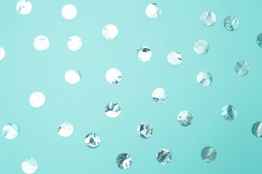Pastel turkuaz kağıt arka plan üzerinde parlak gümüş konfeti Desen. Tatil kavramı, doğum günü, bloglama, güzellik. Üst te. Düz yatıyordu. Minimal tarzı kadar alay. Blog için şablon. Kopyalama alanı