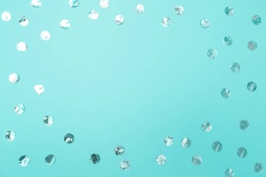 Pastel turkuaz kağıt arka plan üzerinde parlak gümüş konfeti çerçeve. Tatil kavramı, doğum günü, bloglama, güzellik. Üst te. Düz yatıyordu. Minimal tarzı kadar alay. Blog için şablon. Kopyalama alanı