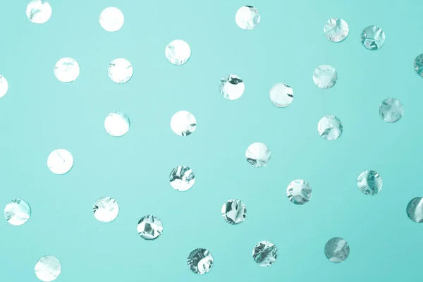 Pastel turkuaz kağıt arka plan üzerinde parlak gümüş konfeti Desen. Tatil kavramı, doğum günü, bloglama, güzellik. Üst te. Düz yatıyordu. Minimal tarzı kadar alay. Blog için şablon. Kopyalama alanı