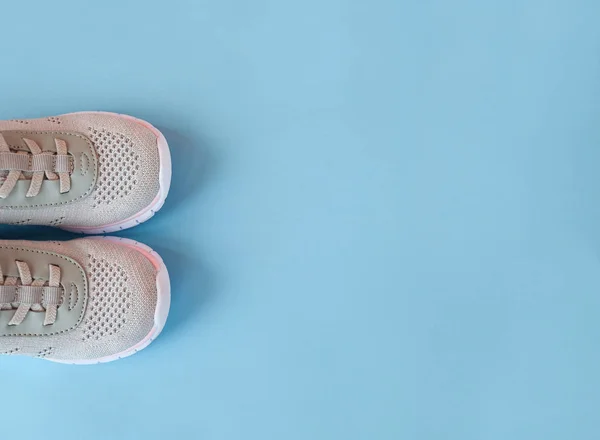 Spor, sağlıklı yaşam tarzı kavramı. Pastel mavi arka planda yeni gri spor ayakkabılar. Kopya alanı. Düz yatıyordu
