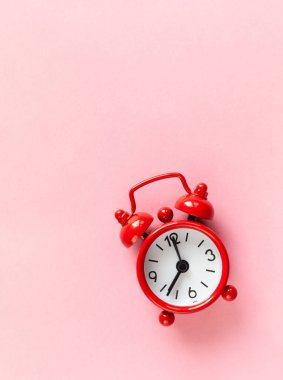 Kopya alanı ile pastel pembe arka plan üzerinde kırmızı küçük çalar saat, düz yatıyordu, makro. Minimal tarzı. Zaman yönetimi kavramı. Dikey