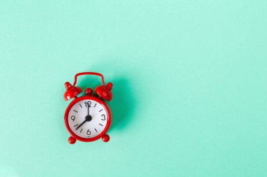 Kopya alanı ile nane rengi arka plan üzerinde kırmızı küçük çalar saat. Minimal tarzı düz yatıyordu. Zaman yönetimi kavramı. Yatay