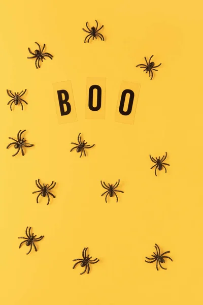 Halloween holiday flat lay. Spiders and inscription Boo on orange background. Minimal style. Vertical. Trick-or-treat concept — Stock Photo, Image