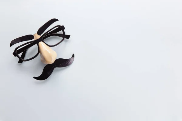 Gri arka planda bıyıklı, burunlu ve gözlüklü karnaval maskesi, kopyalama alanı. Concept Movember, erkek sağlığı, prostat kanseri farkındalığı ayı, hayır işi, Babalar Günü. Yatay olarak. Minimalizm düzlüğü