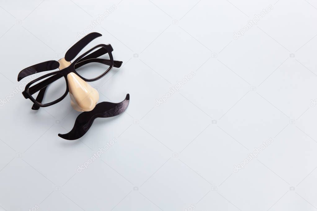 Carnival mask with moustache, nose and glasses on grey background, copy space. Concept Movember, mens health, prostate cancer awareness month, charity, Fathers Day. Horizontal. Minimalism flat lay