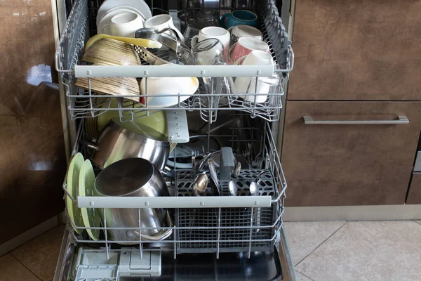 Clean dishes in dishwasher. Freshly washed dishes, plates, cups, jars, mugs, cutlery, pots. Concept of hygiene, household, home care, water saving, technologies and helpers in everyday life.