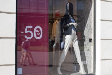 İndirim mevsiminde giyim mağazası vitrini, modern konforlu kadın kıyafetleri mankeni,% 50 indirimli afiş. Konsept alışveriş, kara cuma, satış. Yatay