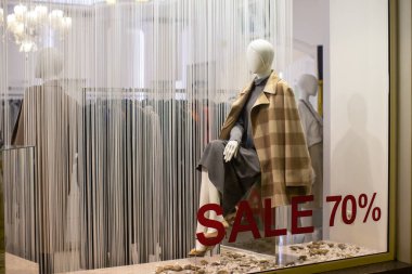 İndirim mevsiminde giyim mağazası vitrini, modern rahat kadın kıyafetlerinde manken, yüzde 70 indirimli yazıtlar. Konsept alışveriş, kara cuma, satış. Yatay.