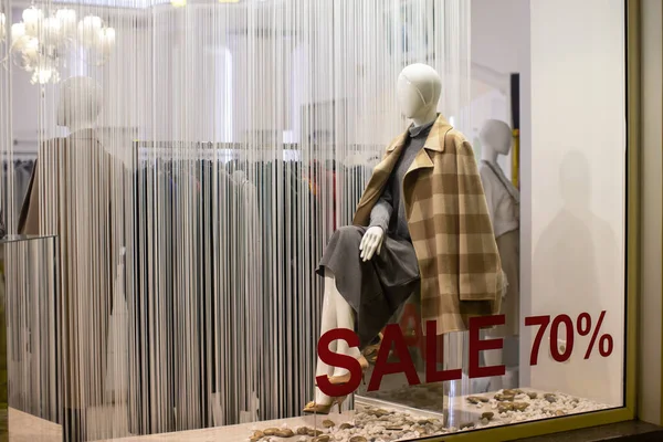 İndirim mevsiminde giyim mağazası vitrini, modern rahat kadın kıyafetlerinde manken, yüzde 70 indirimli yazıtlar. Konsept alışveriş, kara cuma, satış. Yatay.