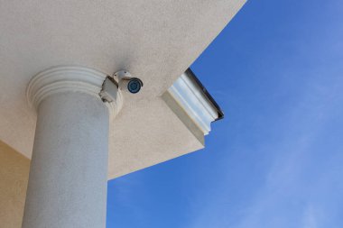 Güvenlik kameraları (kapalı devre televizyon), suçtan korunmak için mavi gökyüzü arka planındaki özel evin çatısına yerleştirildi. Alt manzara. Yatay.