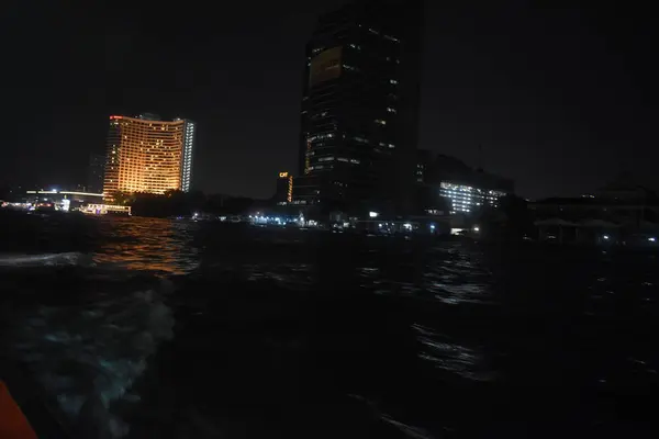 乘着小船在夜景中游览城市夜光中的河流倒影 — 图库照片