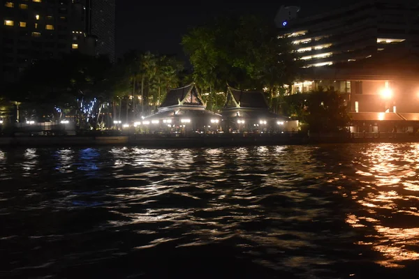 乘着小船在夜景中游览城市夜光中的河流倒影 — 图库照片