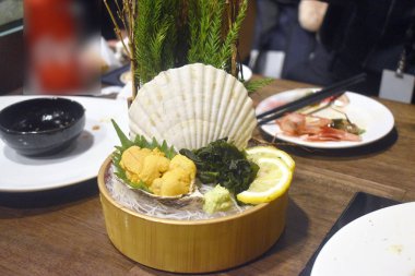 Taze uni veya deniz kestanesi sashimi oba yaprağı ve buz üzerinde kabuk üzerinde servis, geleneksel Japon gıda wasabi ve shoyu sos dap ile yemek.