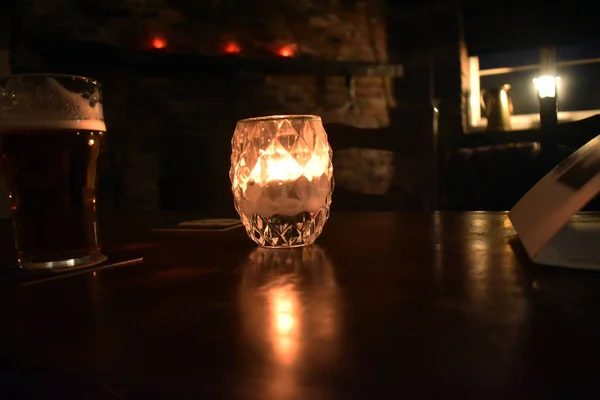 暗い部屋のテーブルの上のガラスのカップからの照明 — ストック写真