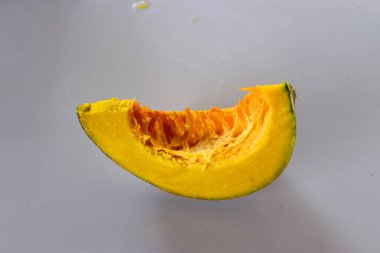 Beyaz arka planda dilimlenmiş balkabağı, organik sebze.