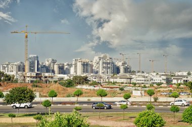 Rishon Lezion, İsrail-Haziran 17, 2017: Yeni Nahlat Yehuda beyaz çok katlı yaşam kuleleri ve bazı kuleleri kaldırma ile yapım aşamasında yaşayan vinç backgroung vardır. Uzak ihtimal.