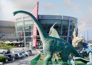 Rishon Letsiyon, İsrail-Nisan 25, 2017: Gerçek boyutu heykeller en bilinen dinozorlar sinema City girişinin önünde çit zemin türü bulunmaktadır. Brachiosaurus yeşil renk heykel önden görünüm lisesinde bağlar.