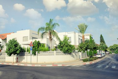 Rishon Letsiyon, İsrail-Ağustos 4, 2017: Yol boyunca beyaz sıvalı 2 katlı özel binalar. Tüm evlerin bazı yeşil bitki örtüsü ile bir avlu var. Konak arazi araziler genel sokak uzaydan ayrılır.