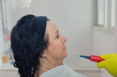 Amatör karısını güzellik bir enjeksiyon yapar. O öz-yapılan plastik şırınga kullanır, çünkü gerçek tıbbi malzeme ve hijyen heavy duty sarı lastik eldiven koyarak devam etmeye çalışır sıkıntısı.