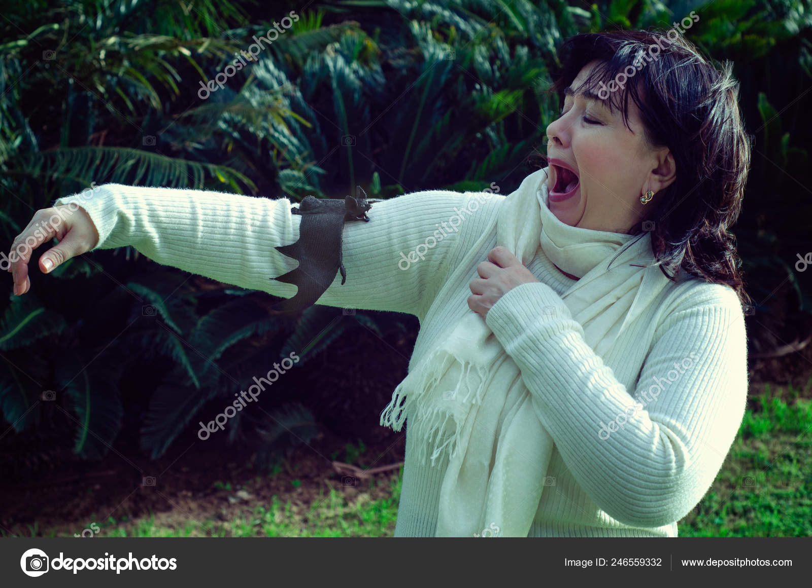 Woman screams in fear because a bat has landed on her arm