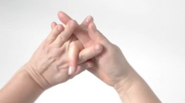 WOMANS avuç içi birlikte katlanmış. Ama orta parmaklar dışarı çıkmış. Farklı yönlere hareket ediyorlar. Eller için jimnastik. Üst görünüm.