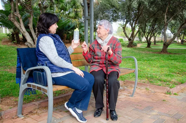 Vrouwelijke Metgezel Verzorger Senior Vrouw Zittend Een Park Bank Oudere — Stockfoto