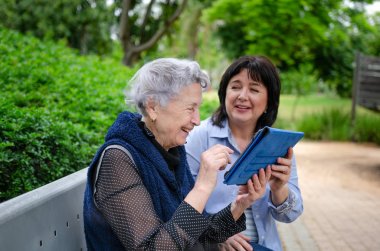 Sevgi dolu kızı nasıl bir tablet kullanmak için yaşlı bir anne öğretir. Yaşlı kadın iyi çalışıyor ve bunu seviyor. Modern teknolojinin yardımıyla, kızı her zaman onunla bağlı kalabilir.