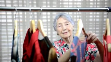 Saldırgan satıcı o mağazadan uzağa gidiyor neden giyim raf yakınında omzuna yaşlı bir kadın dokunuyor.