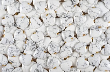 Many heart-shaped semi-precious stones of white howlite as background clipart