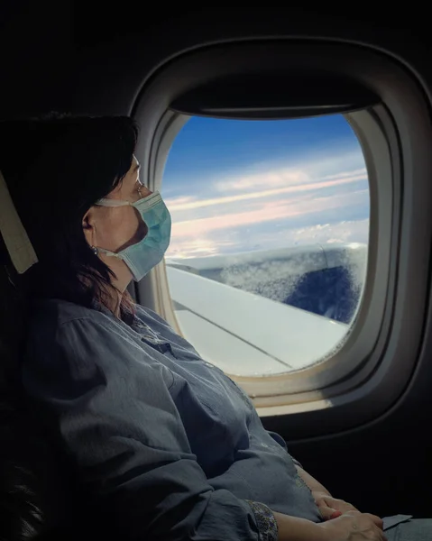 Starší Žena Obličejovou Maskou Cestující Letadlem Noční Snímek Naproti Oknu — Stock fotografie