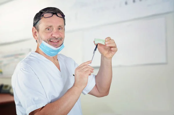 Serdeczny Chirurg Dentysta Białym Mundurze Ukazujący Górną Część Odlewu Dentystycznego — Zdjęcie stockowe