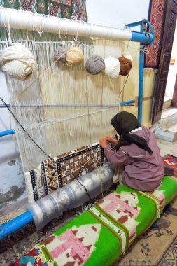 Kadın Kairouan, Tunus elle bir halı weaves. 