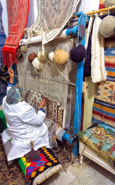 Mujer teje una alfombra tradicional a mano en Kairuán, Túnez . — Foto de Stock