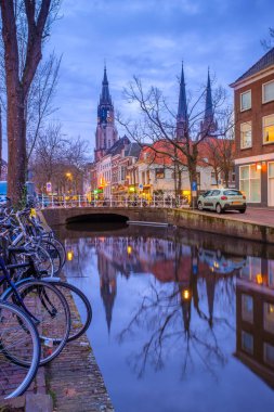 Leiden, Hollanda - 5 Nisan 2018: Akşam alacakaranlıkta aydınlatılmış su kanalıyla sokakta tipik Hollanda mimarisi