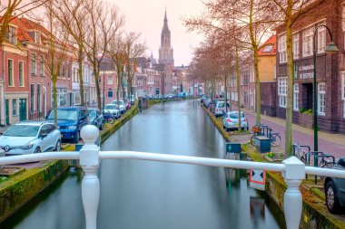 Amsterdam yakınlarındaki Delft 'teki kanal ve kilise için akşam manzarası. Baharda gün batımında Hollanda şehri. Hollanda, Hollanda.