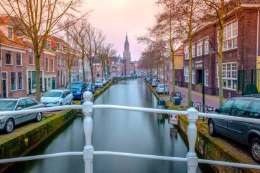 Amsterdam yakınlarındaki Delft 'teki kanal ve kilise için akşam manzarası. Baharda gün batımında Hollanda şehri. Hollanda, Hollanda.