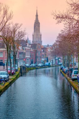 Amsterdam yakınlarındaki Delft 'teki kanal ve kilise için akşam manzarası. Baharda gün batımında Hollanda şehri. Hollanda, Hollanda.