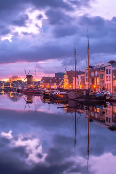 stock image View of the canals of the city of Leiden with hoses, mill, ships and boats at sunset. View of city channel with ships, the city of Leiden, Netherlands.