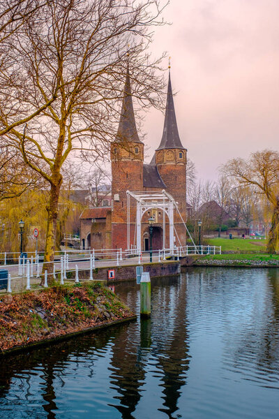 Evening view of the canal and the VVE Oostpoort de Delft. Dutch city in the spring at sunset. Holland, Netherlands.