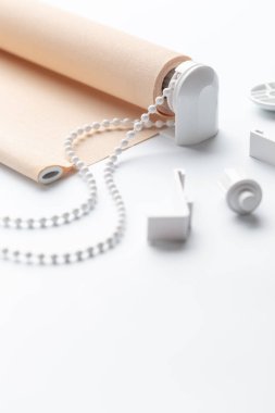 beyaz yüzeyüzerinde plastik parçaları ile haddelenmiş bej kepenk