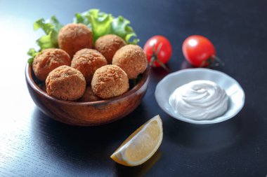 Domates ve sos ile masada kase kızarmış falafel topları